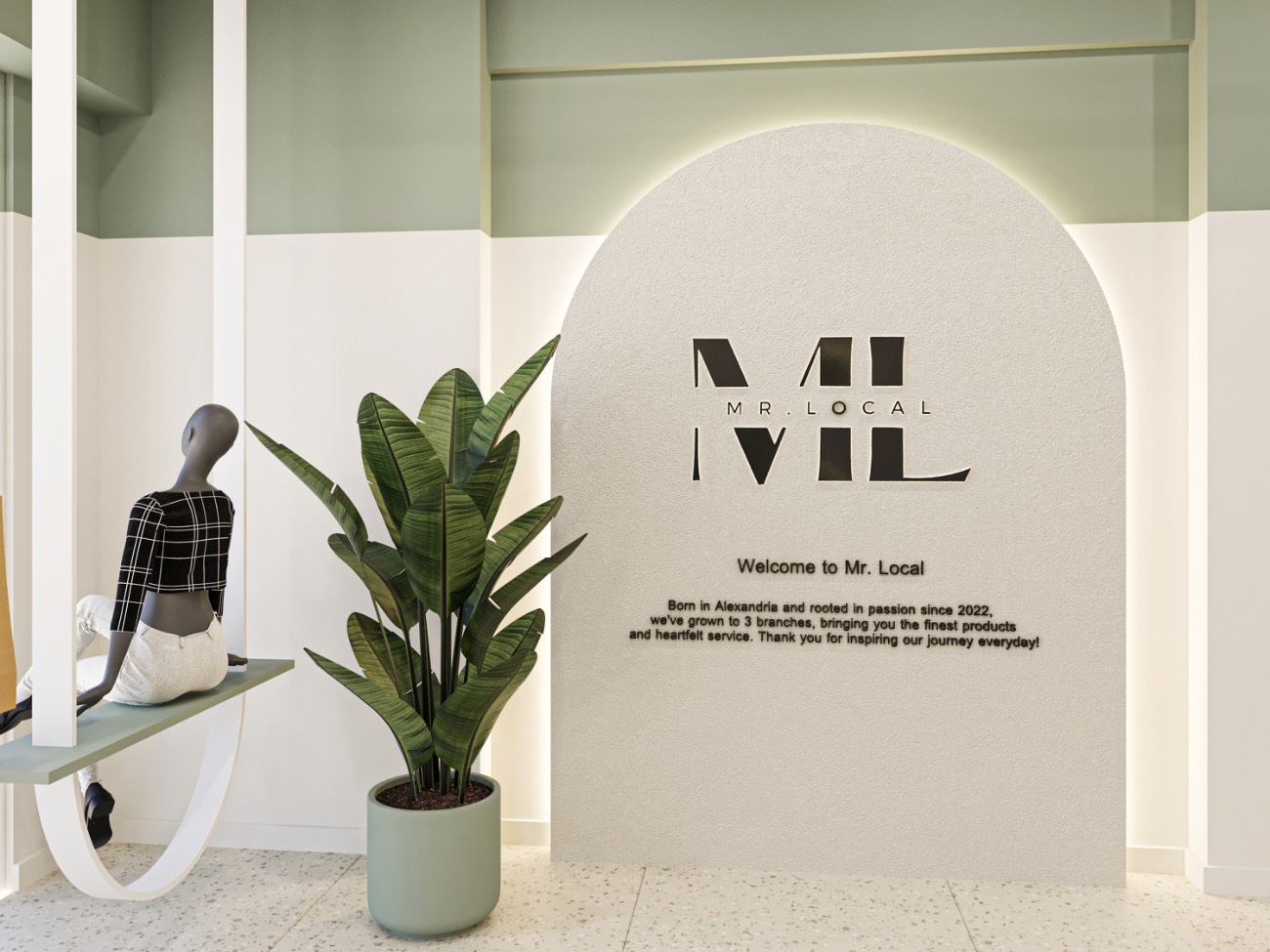 The arched welcome monolith inside the store, carrying the ML monogram and the welcome note, beside a tall plant